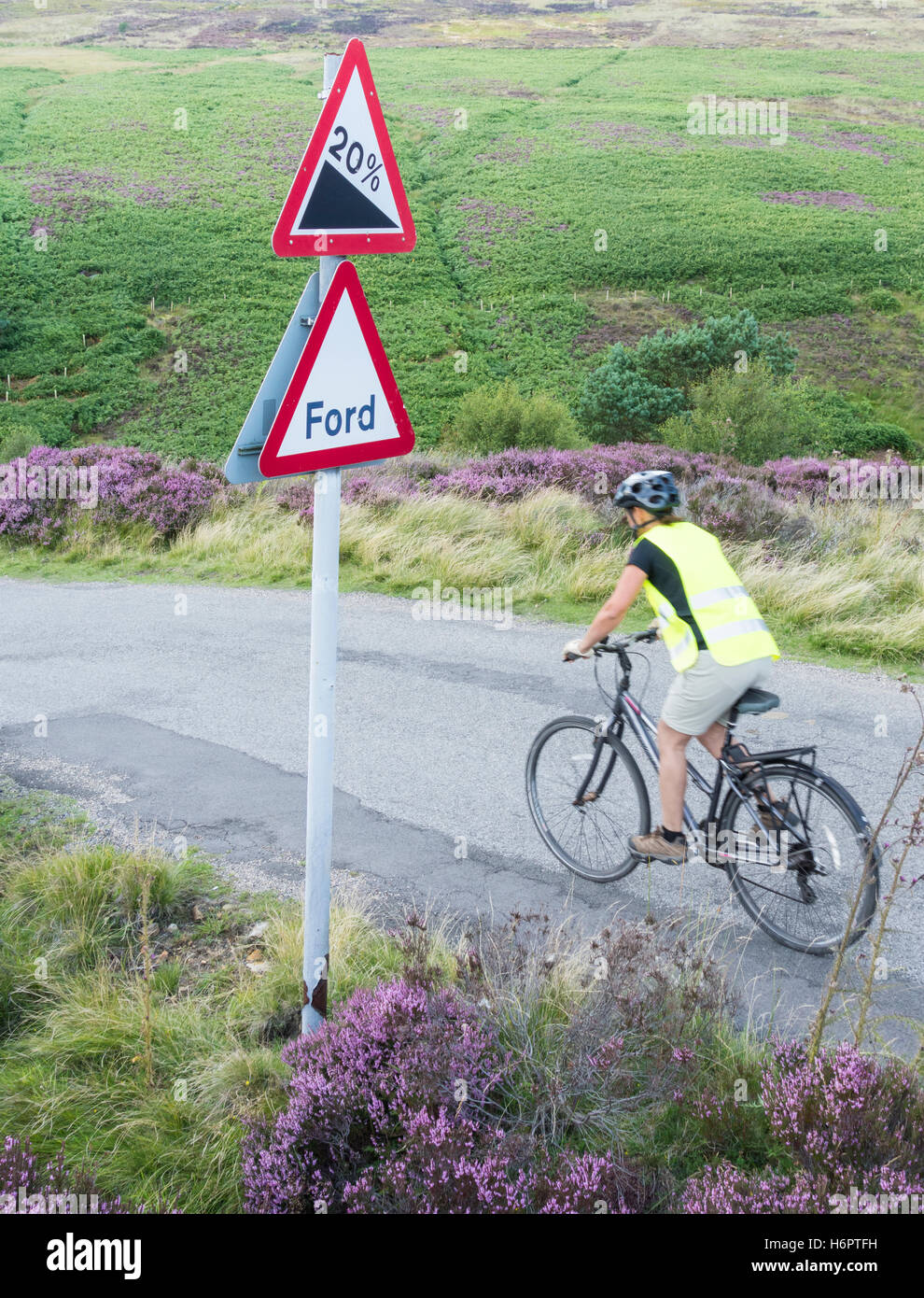 Female cyclist on country road at Westerdale, North York Moors National Park, North Yorkshire, England. UK Stock Photo