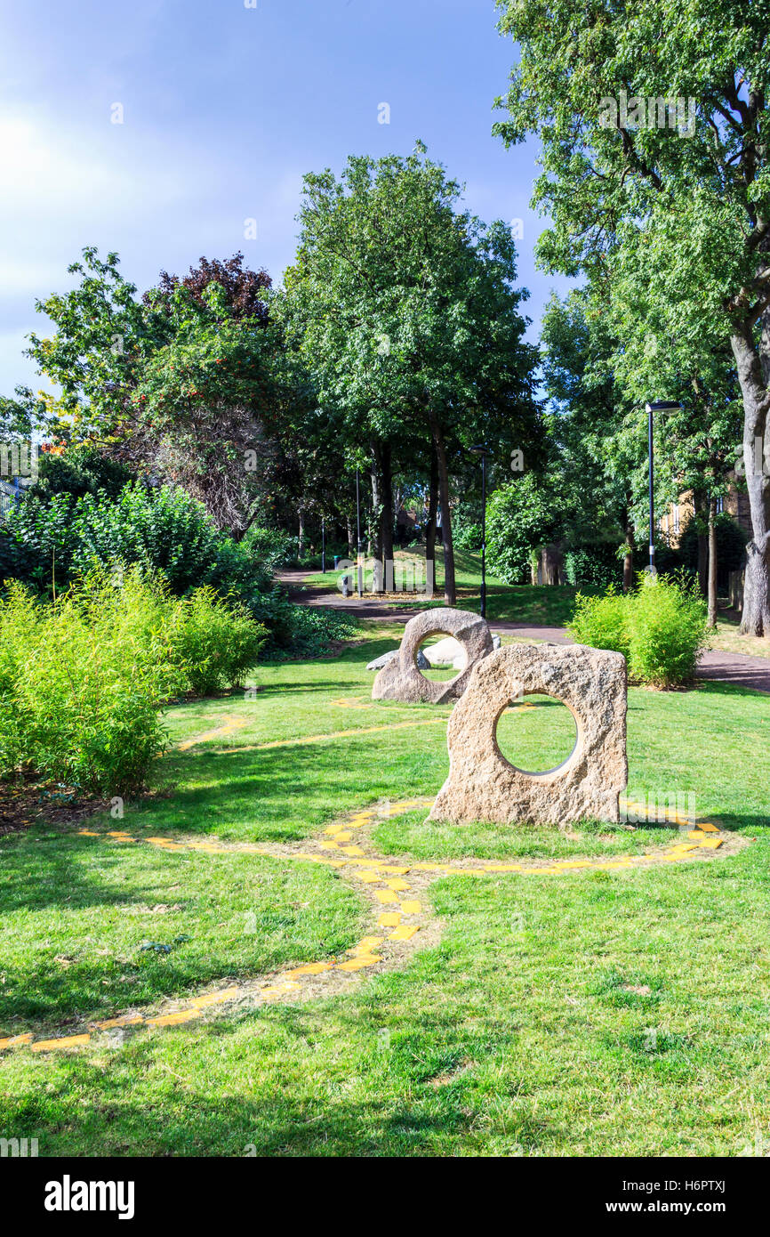 Winding yellow brick path around ornamental sculptures in Hillside Park, North London, UK Stock Photo