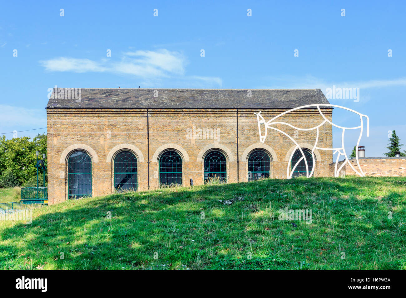 The Pumping Station in Markfield Park, Tottenham, North London, UK, a metal sculpture of a bull or cow (by Jack Gardner) on the right. Stock Photo