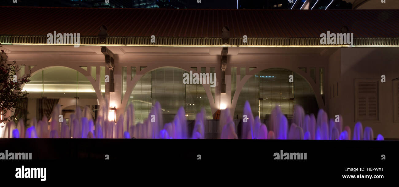 Little water fountain Singapore at night in front of colonial building