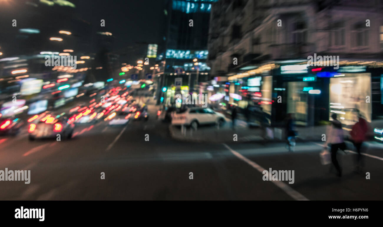 Night city street lights background. Blurred motion of people and cars Stock Photo