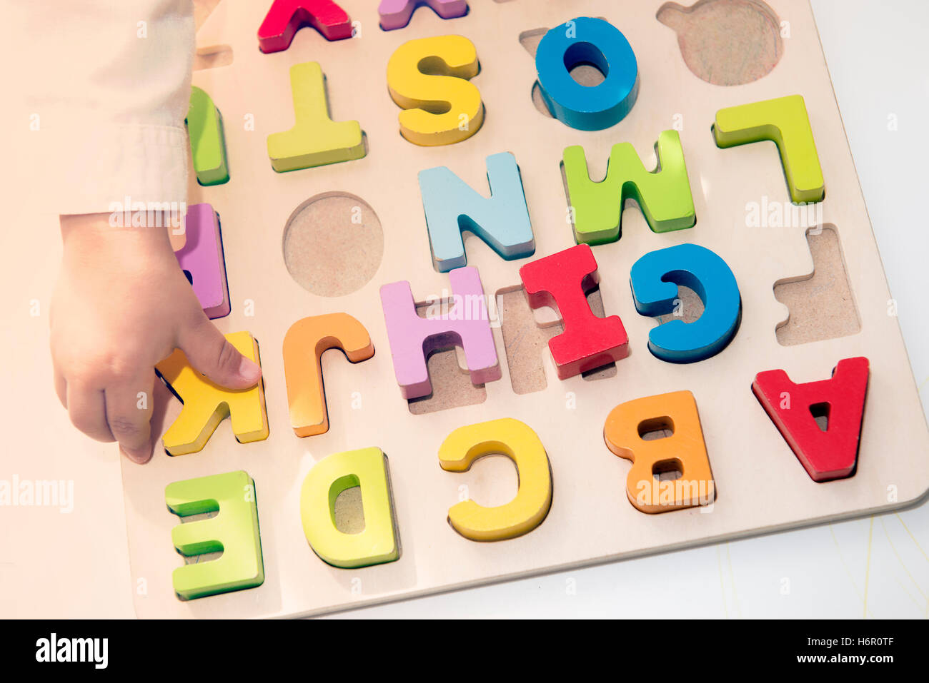 child plays with wooden letters preschool game to develop intelligence Stock Photo