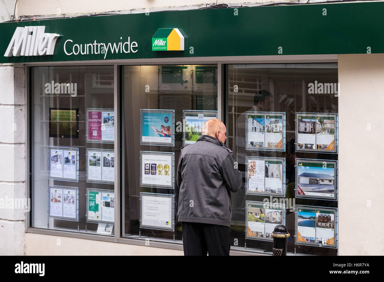 A man looking at in a Miller Countrywide estate agent window in Falmouth, Cornwall. Stock Photo