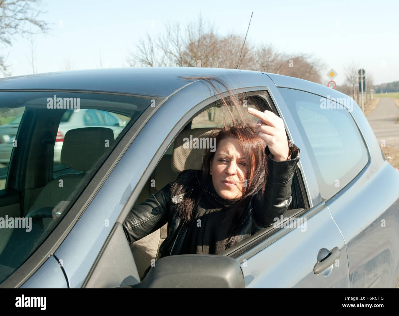 woman car automobile vehicle means of travel motor vehicle middle finger upbraid annoyed raving furious angry irately cursing Stock Photo