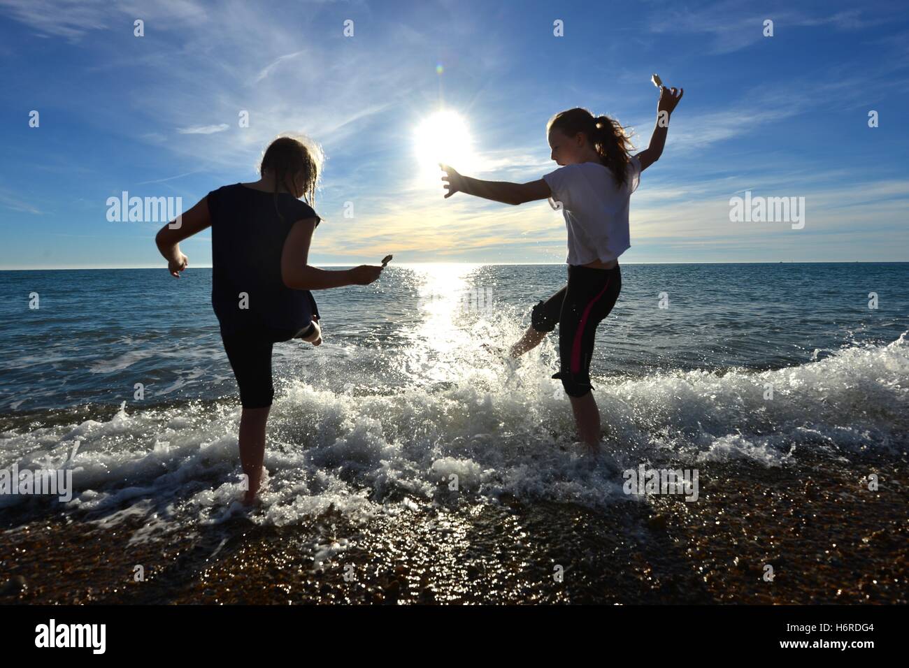 Seaford, Sussex, UK. 31st October, 2016. Children splashing in the sea with ice creams during unseasonably warm weather. Credit:  Peter Cripps/Alamy Live News Stock Photo
