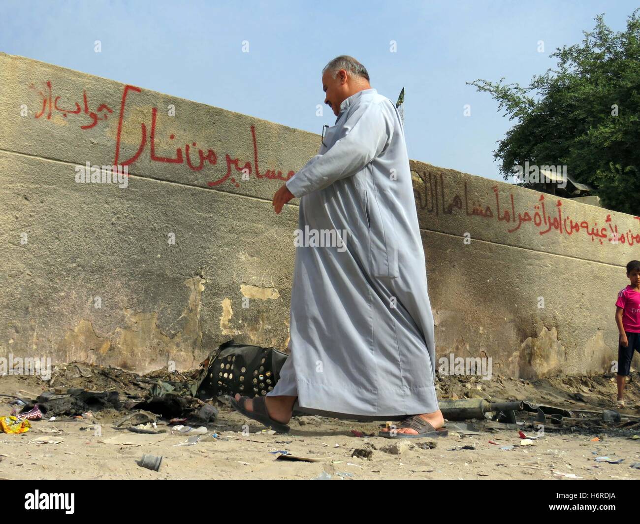 (161031) -- BAGHDAD, Oct. 31, 2016 (Xinhua) -- A man walks at the site of a bomb attack in Baghdad, Iraq, on Oct. 31, 2016. At least five people were wounded on evening Sunday in a bomb attack targeting citizen people in Hoorya district northern Baghdad, a Iraq police source said. (Xinhua/Khalil Dawood)(dtf) Stock Photo