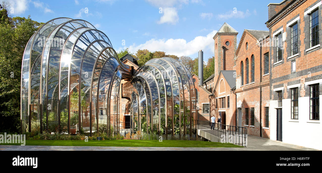 Historic mill site with curving greenhouse additions. Bombay Sapphire Distillery, Laverstoke, United Kingdom. Architect: Heatherwick, 2014. Stock Photo