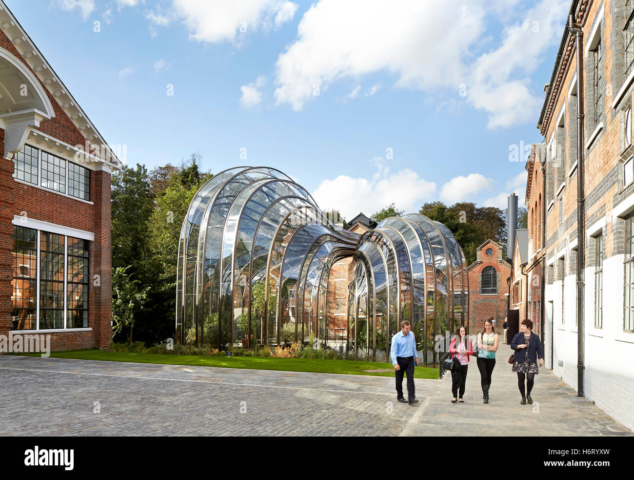 Historic mill site with curving greenhouse additions. Bombay Sapphire Distillery, Laverstoke, United Kingdom. Architect: Heatherwick, 2014. Stock Photo
