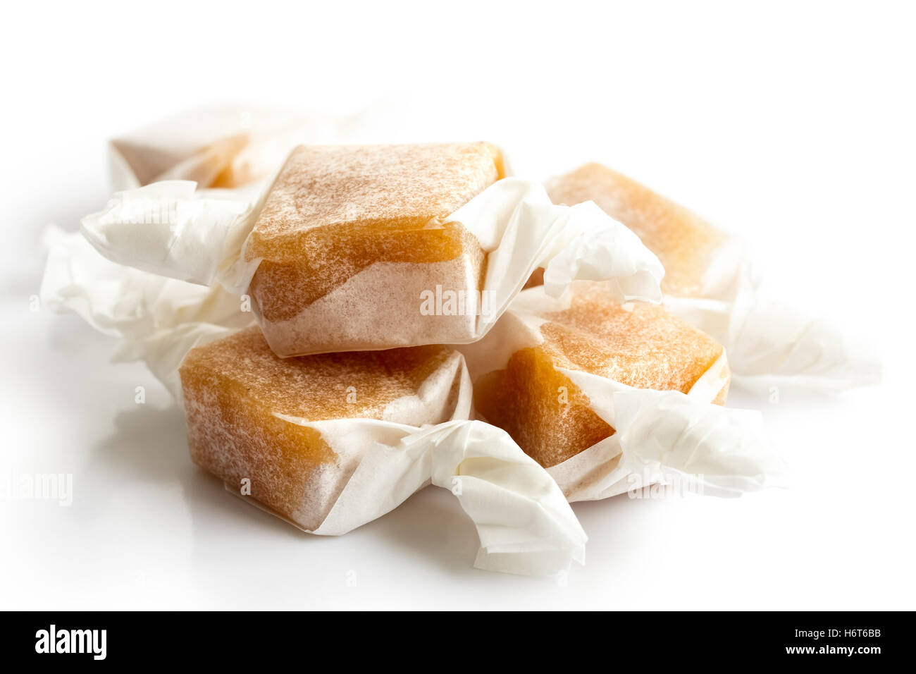 Pile of luxury wrapped caramel toffees isolated on white in perspective. Stock Photo