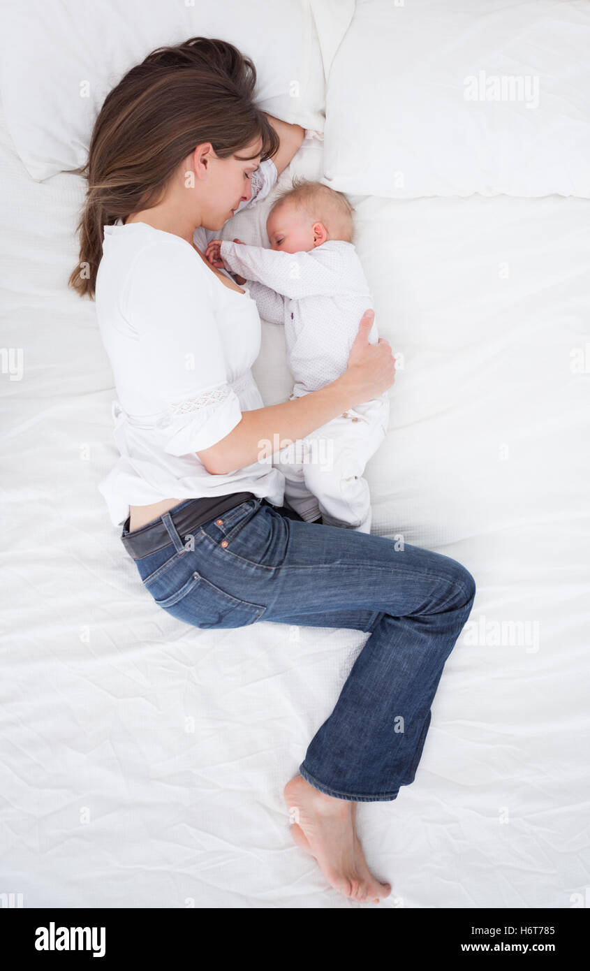woman lying next to her baby in a bedroom Stock Photo Alamy