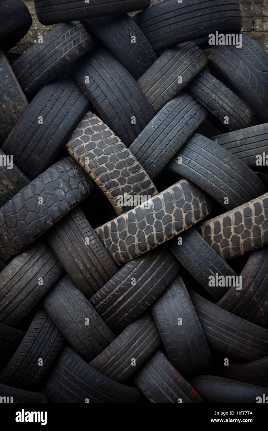A pile of old rubber  car tyres stacked and waiting for collection for recycling, UK Stock Photo