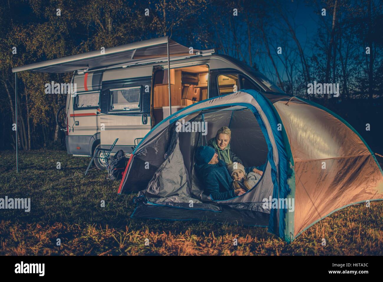 Caucasian Family Camping Fun. Caucasian Family in the Tent. RV Motorhome Camper in the Background. Stock Photo