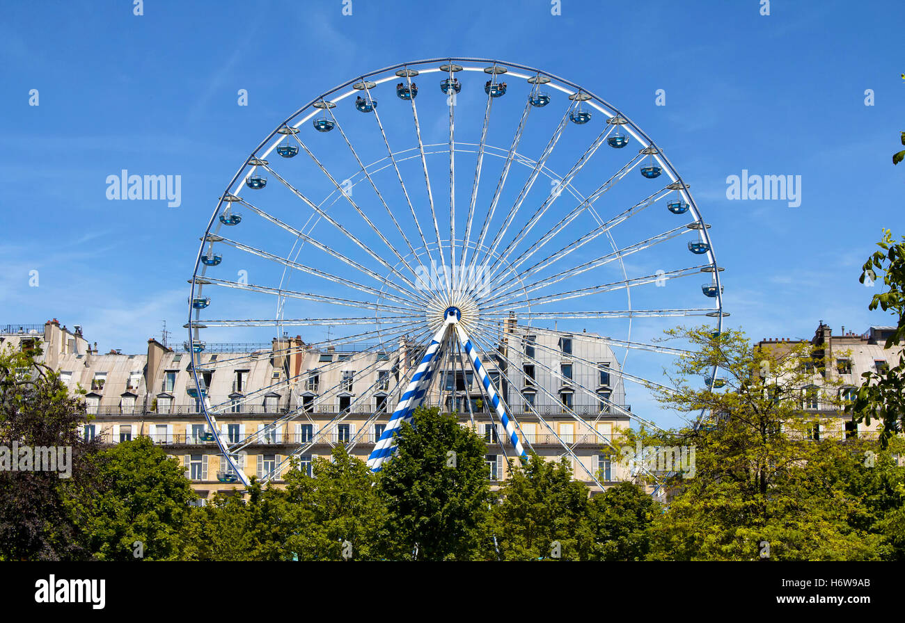 View of Ferris wheel, trees and buildings at Jardin Des Tuileries in Paris. Stock Photo