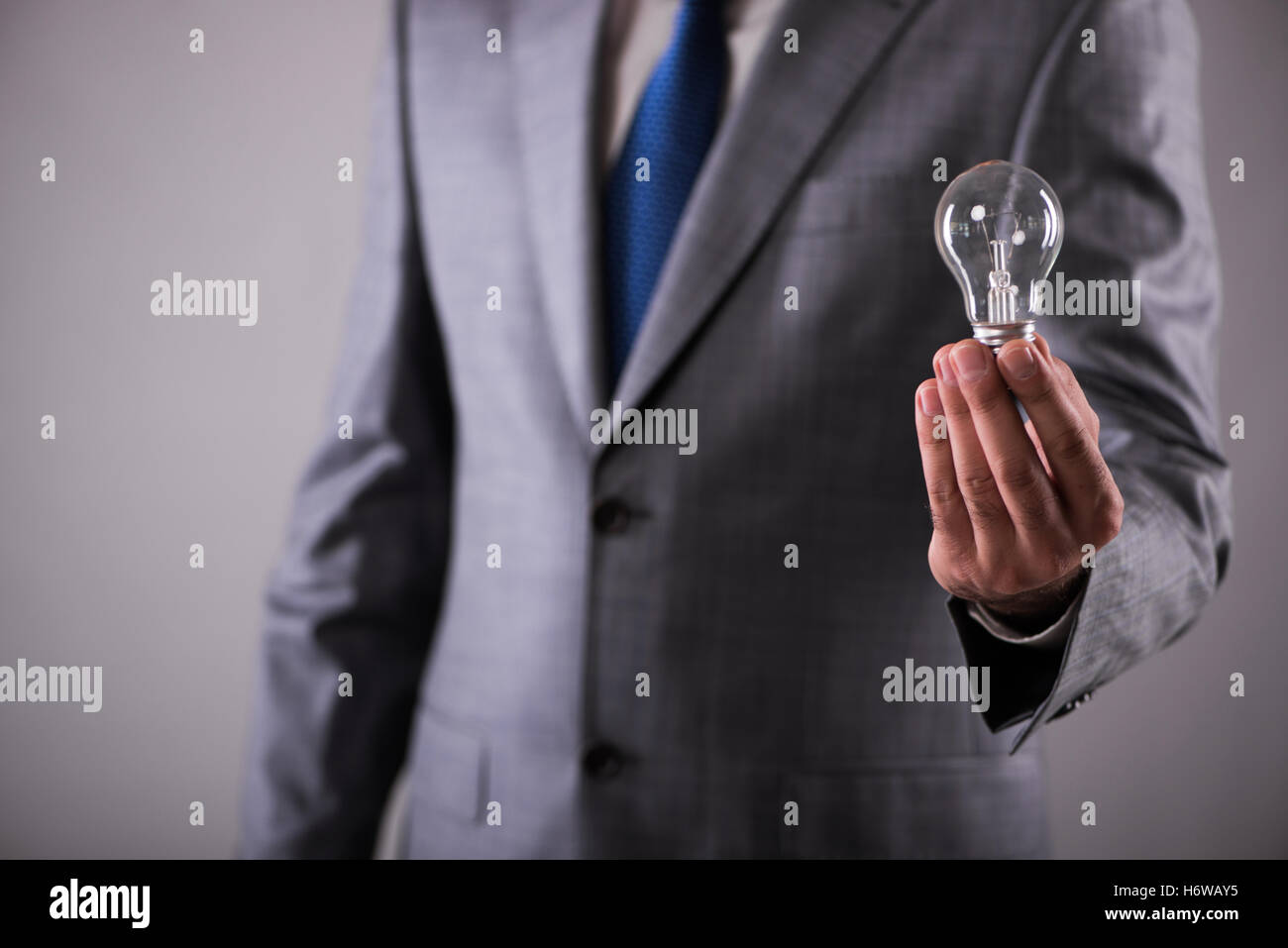 Businessman holding light bulb in creativity concept Stock Photo - Alamy