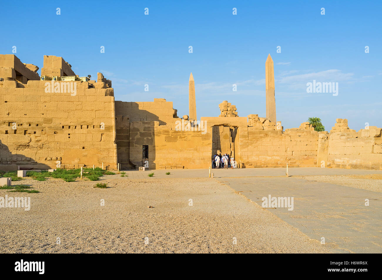The side wall of the Karnak Temple hides two slender granite obelisks, Luxor, Egypt. Stock Photo