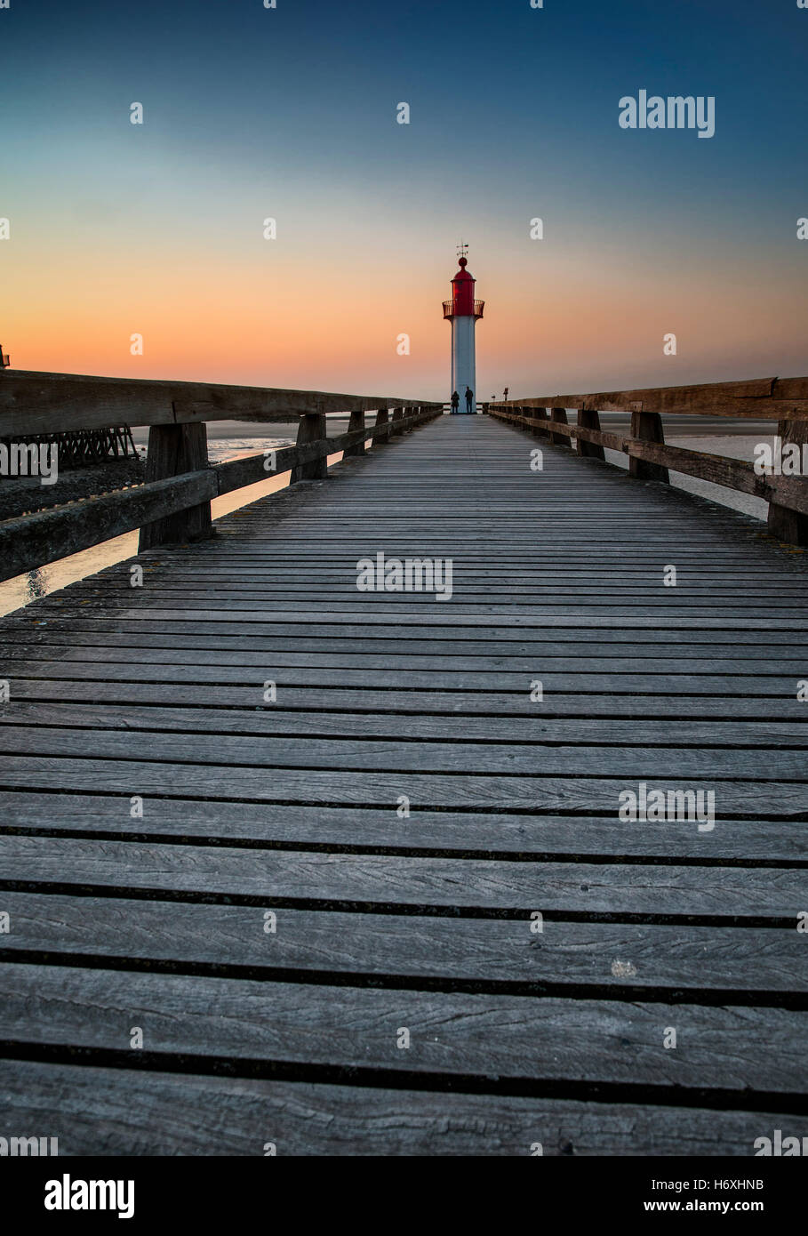 Sunset and Evening Mood at the Beach of Deauville with Pier and Lighthouse during Ebb Tide Stock Photo