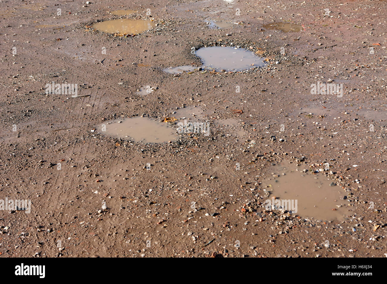 potholes in a rough gravel car parking area england uk Stock Photo