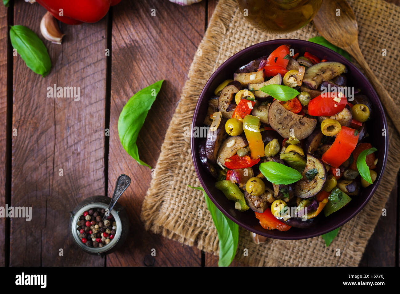 Hot spicy stew eggplant, sweet pepper, olives and capers with basil