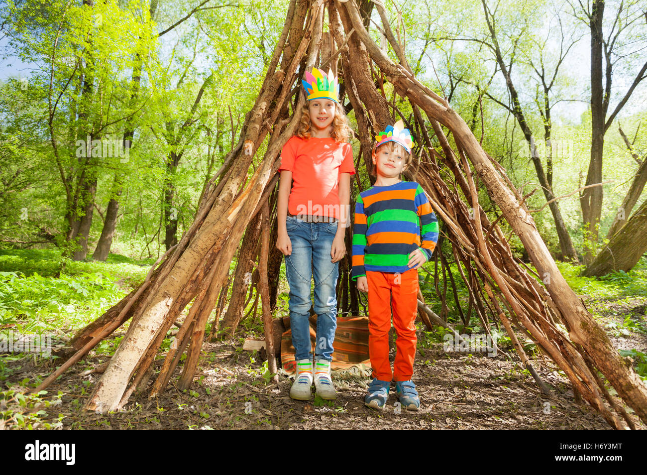 Two happy kids playing Injuns in the forest Stock Photo