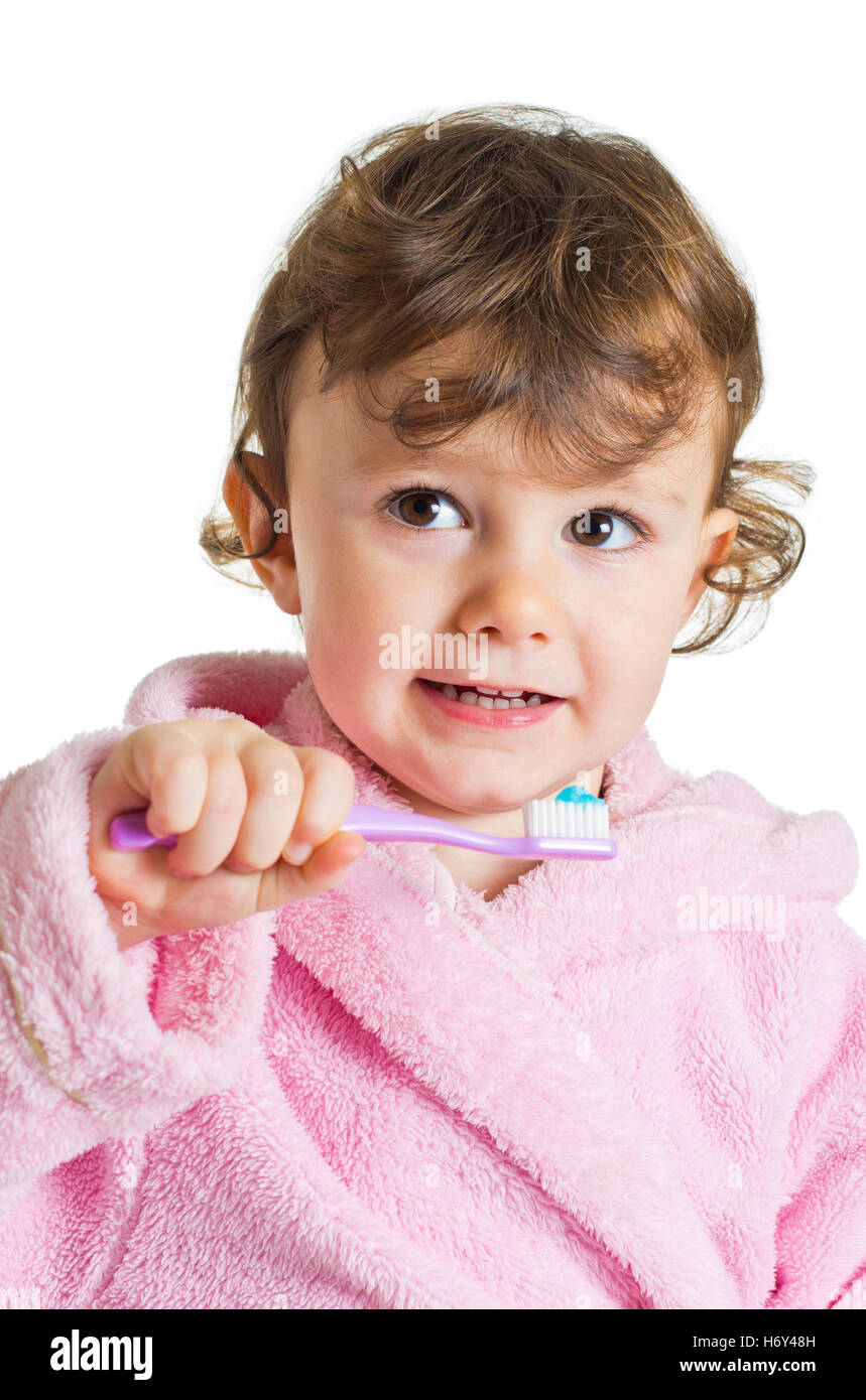Three years old girl in pink dressing gown/bathrobe brushing her teeth
