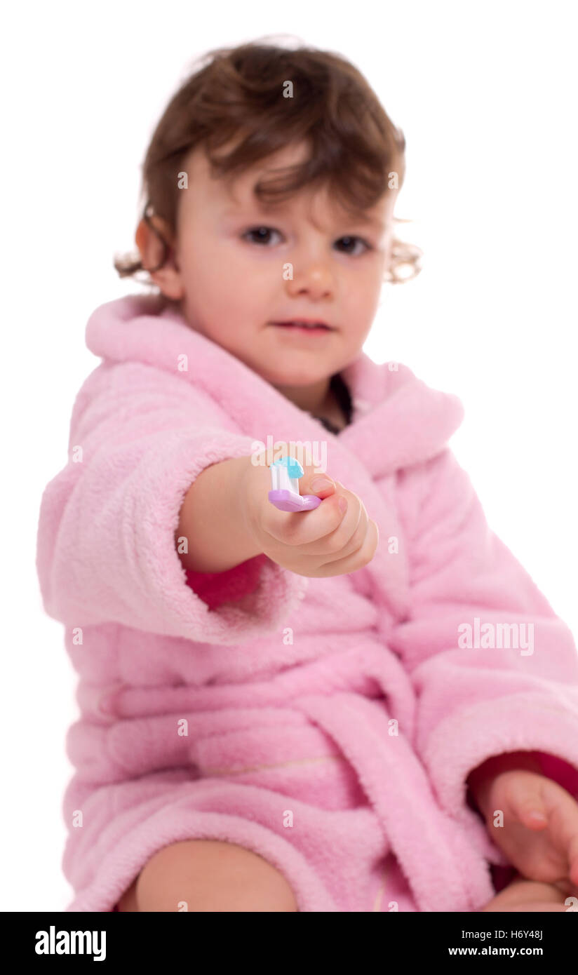 Three years old girl in pink dressing gown/bathrobe brushing her teeth