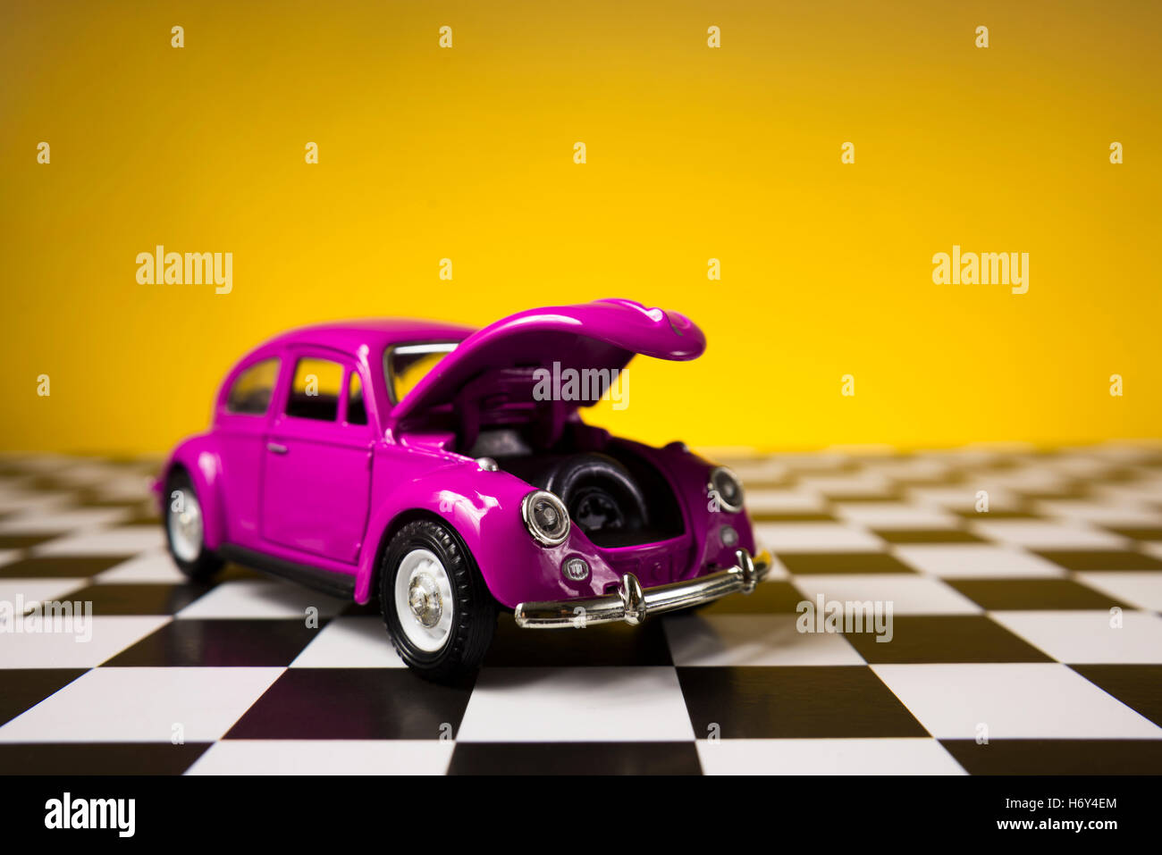 Izmir, Turkey - November 21, 2015. Still life shot of a Pink volkswagen beetle on a yellow background and checked floor. Stock Photo