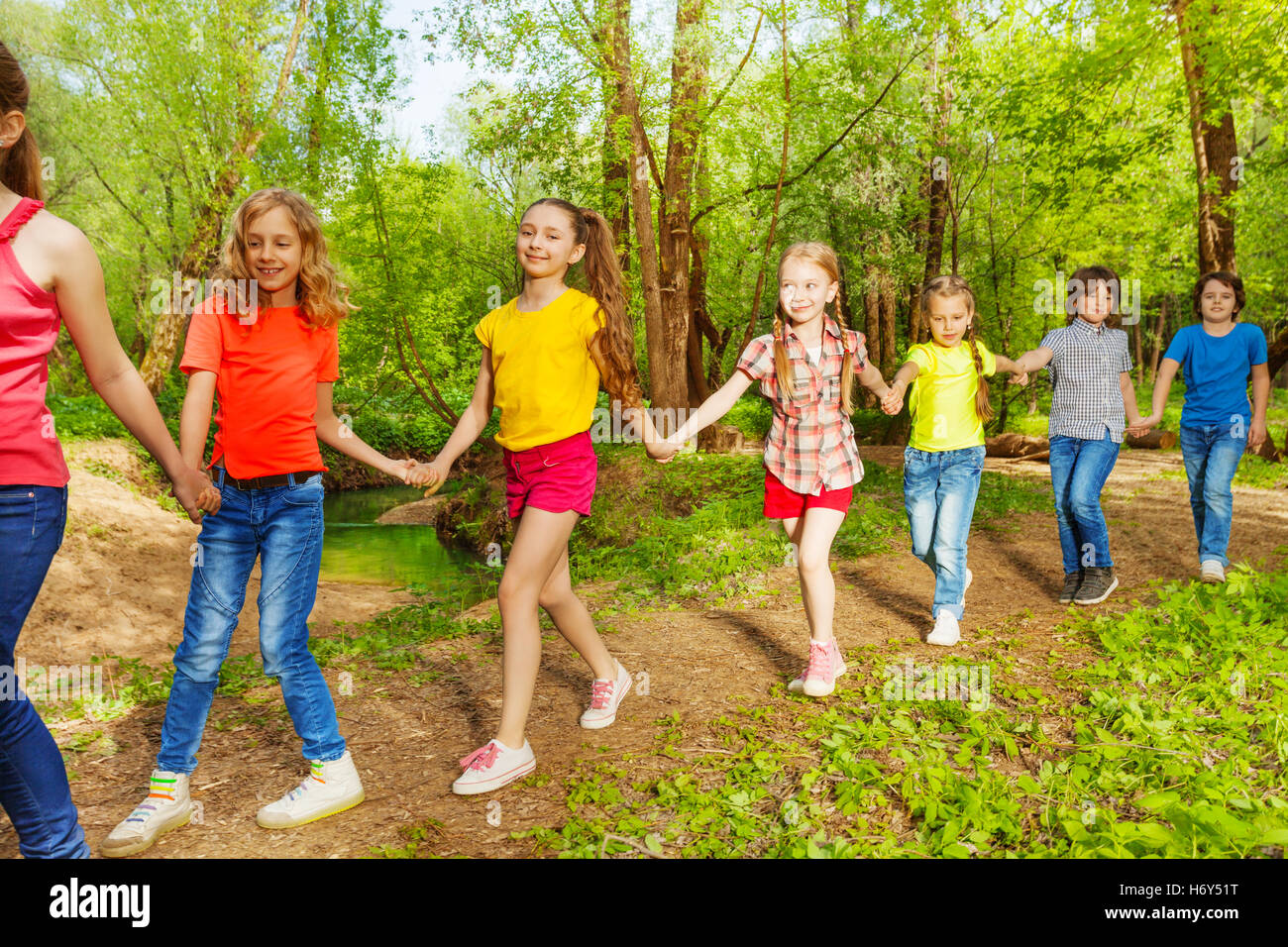 Happy children walking in the forest holding hands Stock Photo Alamy
