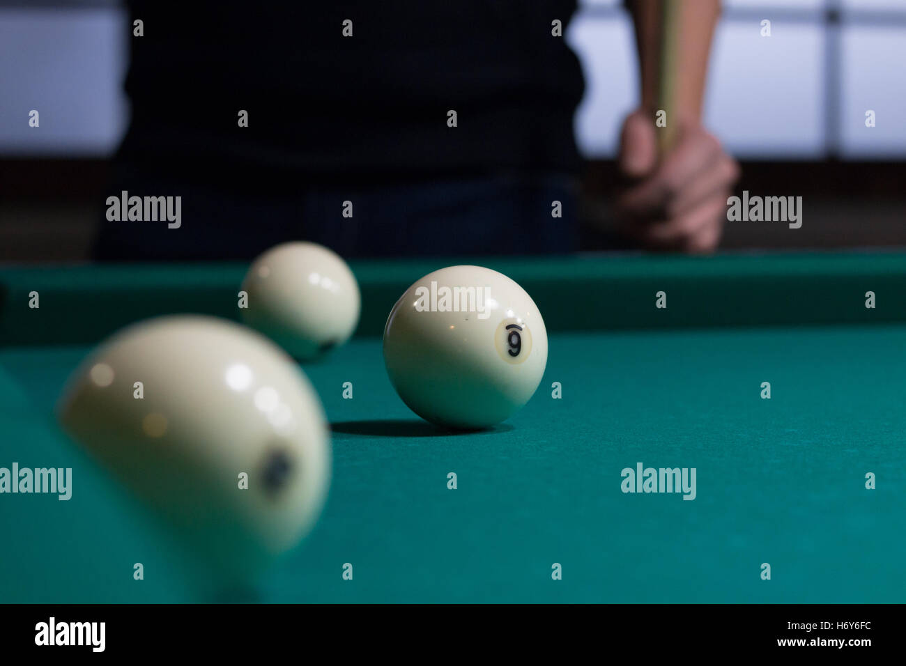 Close-up of Russian billiards game in process: three white balls on green  game table cloth and player with cue on background Stock Photo - Alamy