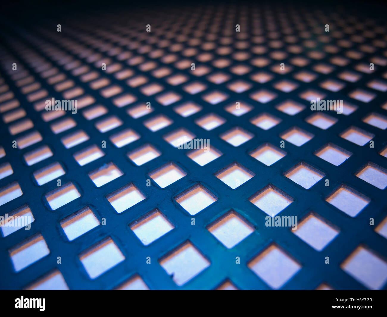 Wide and flat angled view on a grid plate with square cut-outs. Stock Photo