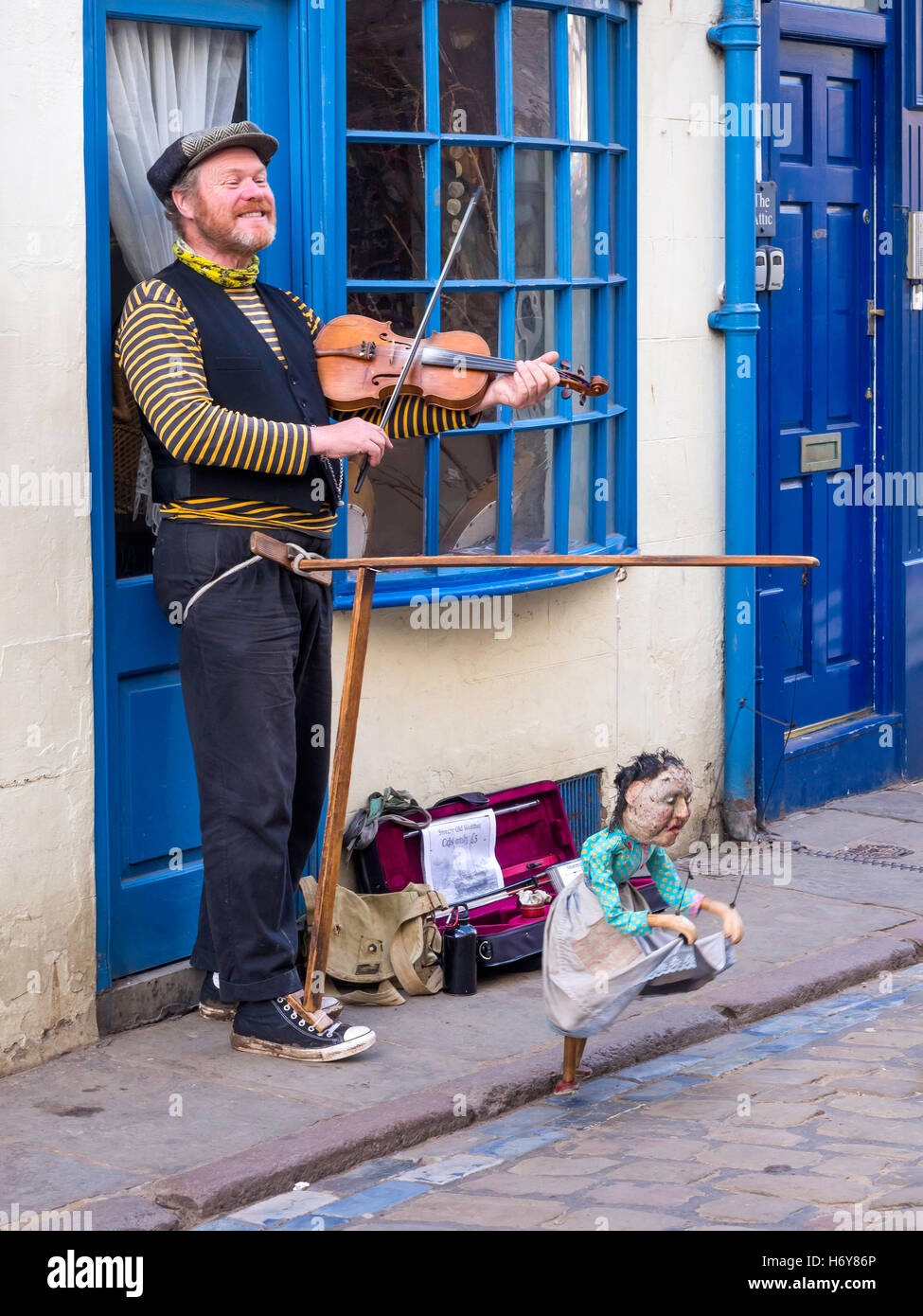 Street musician with a dancing doll singing sea songs and playing violin in Whitby Stock Photo