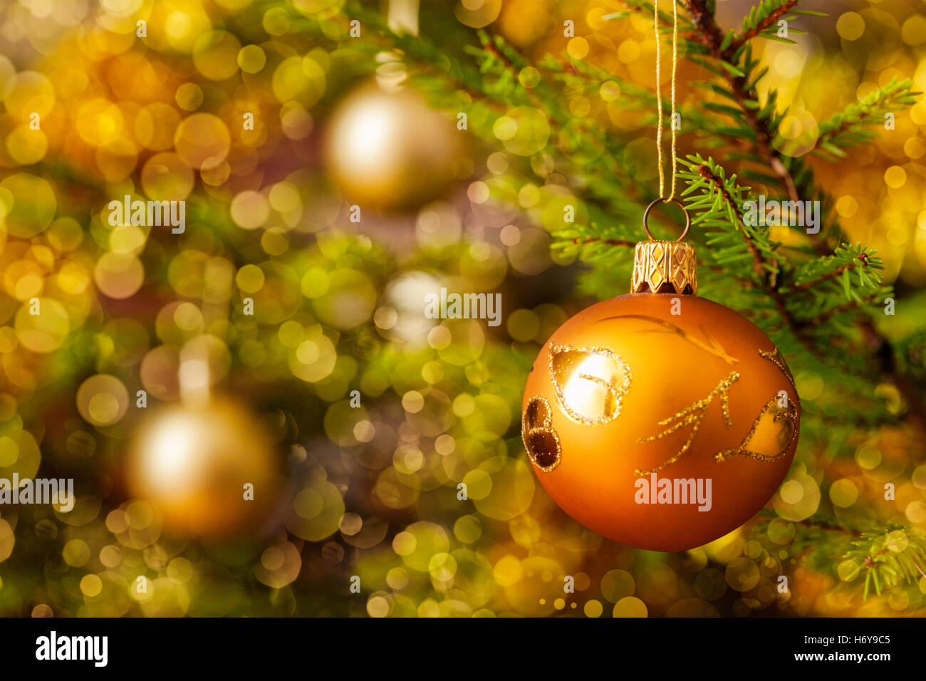 Decoration bauble on decorated Christmas tree background Stock Photo