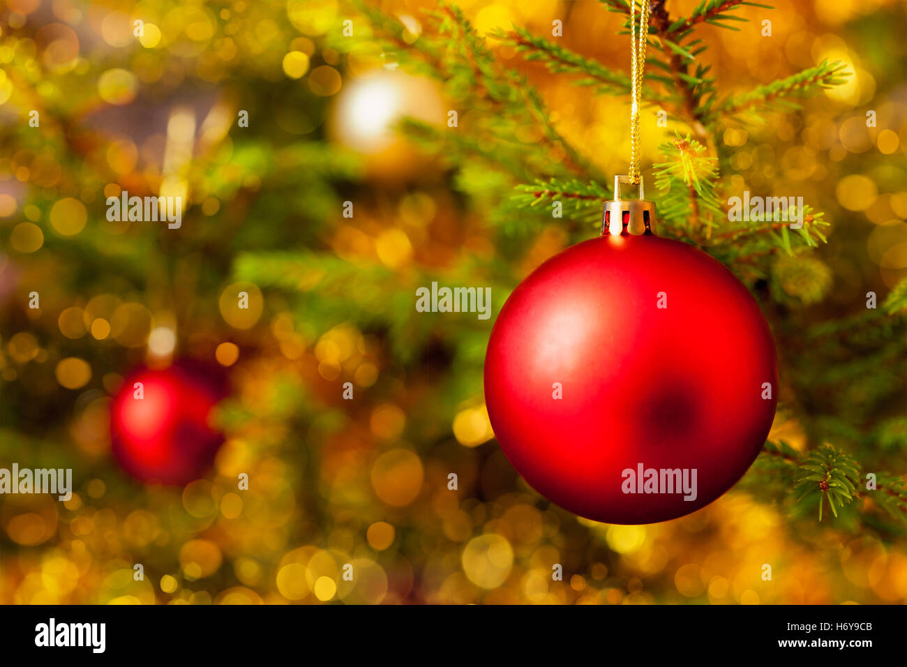 Decoration bauble on decorated Christmas tree background Stock Photo