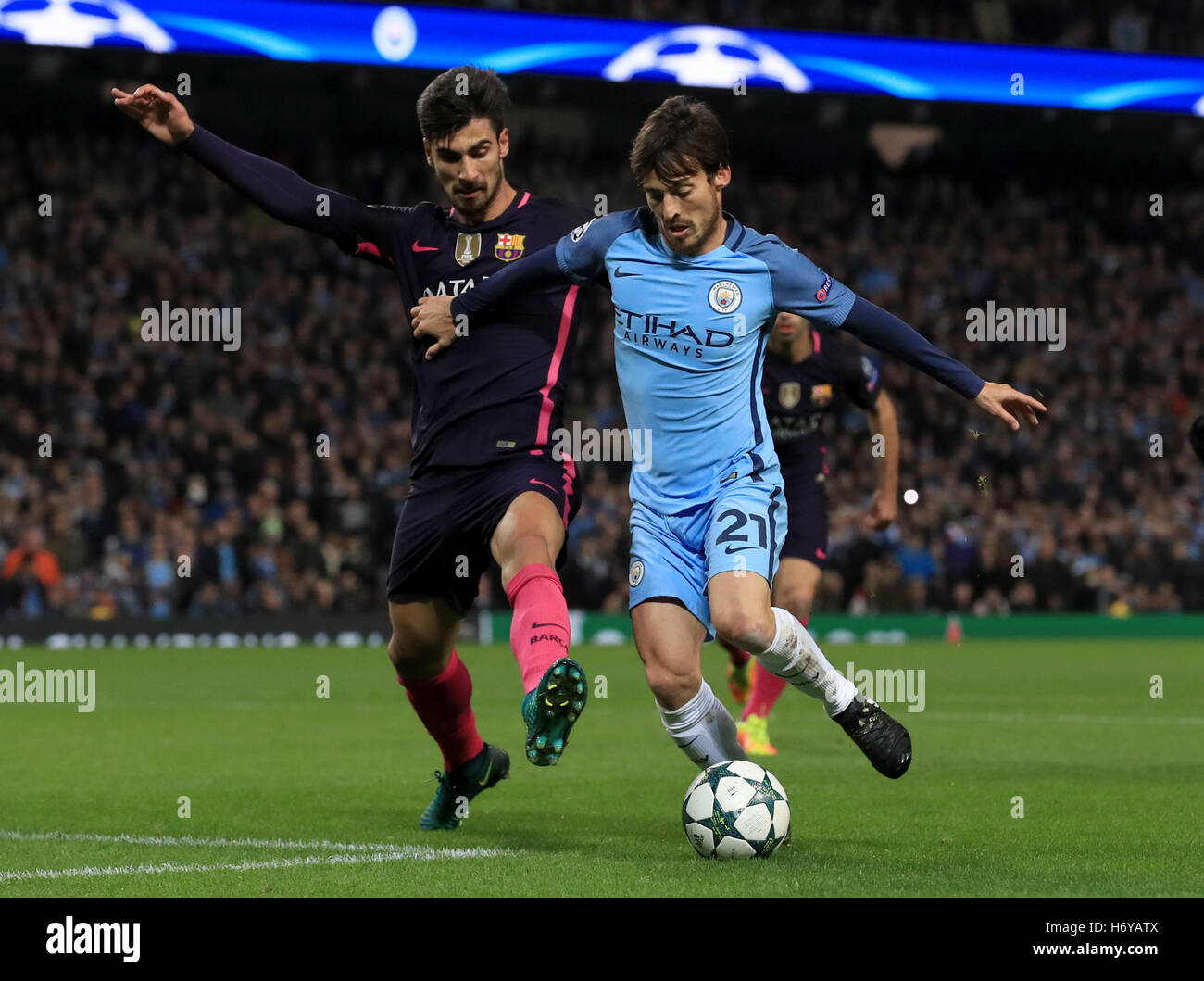 Barcelona's AndrÃ© Gomes (left) battles for the ball with Manchester City's David Silva (right) during the UEFA Champions League match at the Etihad Stadium, Manchester. Stock Photo