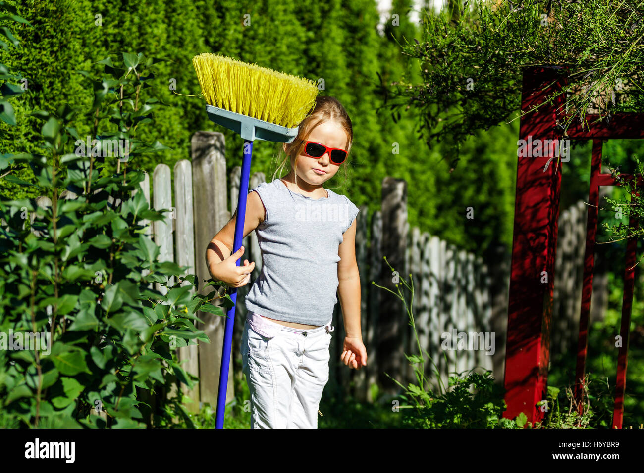 Cute little girl helping mother in the garden, summer day Stock Photo ...