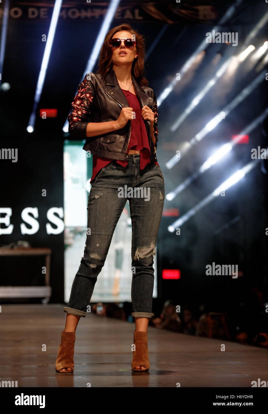 A model poses on the runway at the Guess fashion show held during the  Fashion and Design Festival in downtown Montreal Stock Photo - Alamy