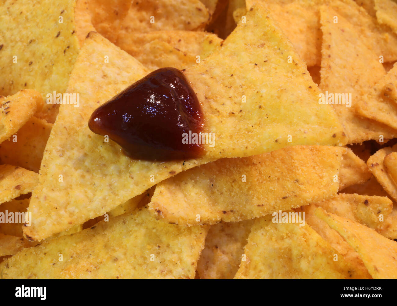 background of Fragrant yellow tortillas chips with hot sauce dip Stock