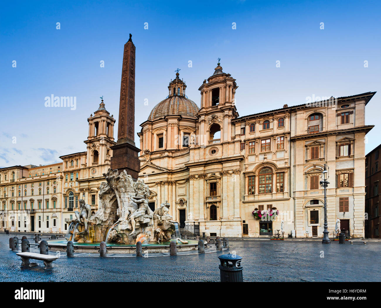 Four rivers (Fiumi) fountain at Navona square in Rome in front of St Agnese church at sunrise when no tourists Stock Photo