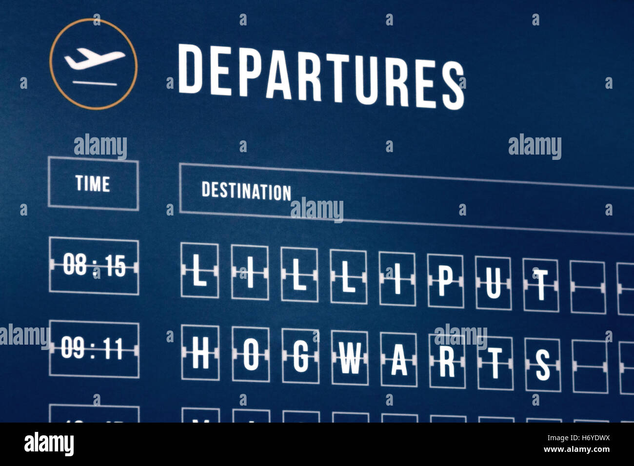 An airport departures timetable with fictional places (Lilliput and Hogwarts) Stock Photo