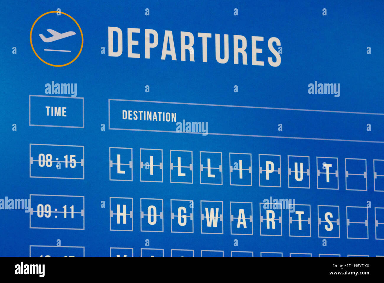 An airport departures timetable with fictional places (Lilliput and Hogwarts) Stock Photo