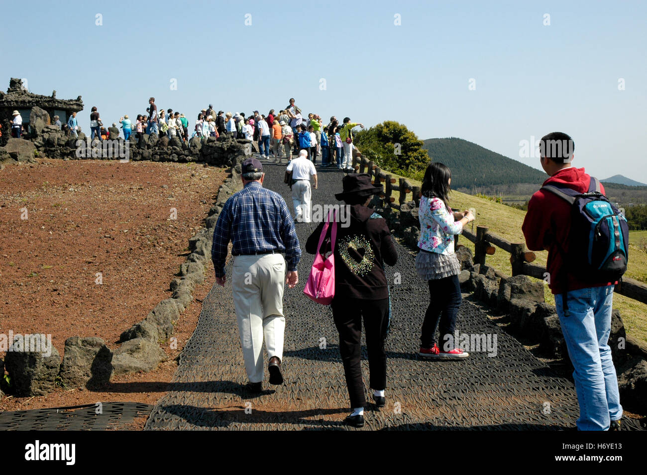 visitors on path to pavillion made of volcanic rock on rim of sangumburi crater. jeju (cheju) island. sth. korea Stock Photo