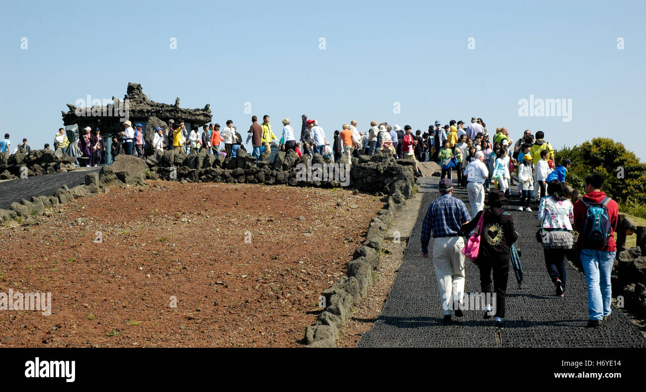 visitors on path to pavillion made of volcanic rock on rim of sangumburi crater. jeju (cheju) island. sth. korea Stock Photo