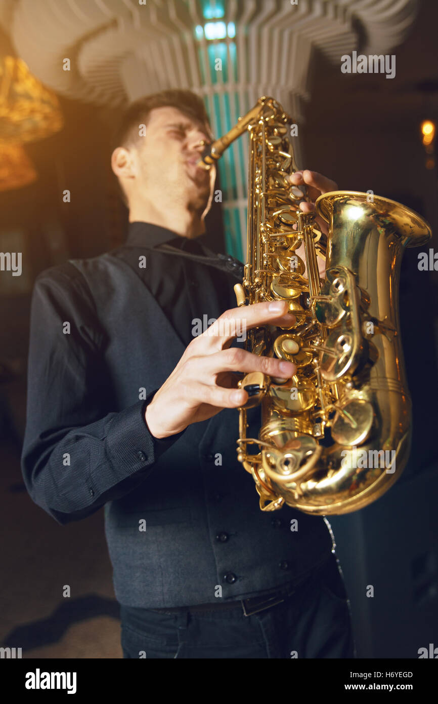 Young Man Plays Mini Saxophone with Bare Hands Stock Photo - Image