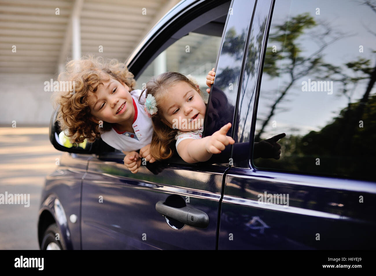 Ребенок в окне машины. Ребенок выглядывает в окно машины. Ребенок в окне машины. Ребенок выглядывает из окна машины. Ребенок высовывается из окна машины.