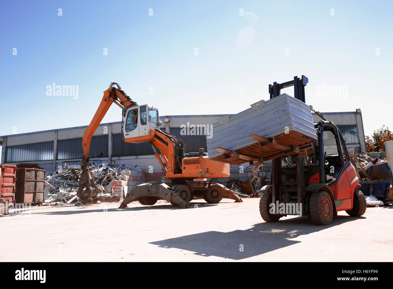 Crane grab and fork lift truck sorting and moving metals in scrap yard  Image downloaded by   at 10:17 on the 14/06/15 Stock Photo