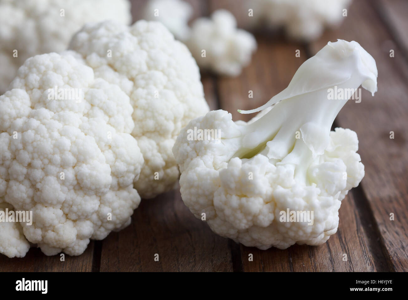Fresh cauliflower florets on a dark wood board. Stock Photo