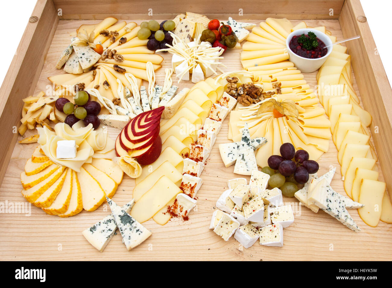 Mixed cheeses on a large light wooden board. Stock Photo
