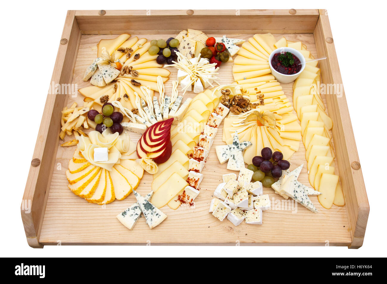 Mixed cheeses on a large light wooden board. Stock Photo