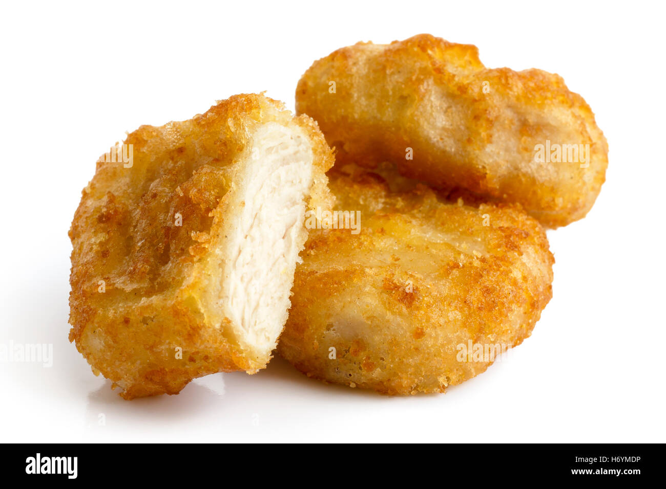 Three golden deep-fried battered chicken nuggets isolated on white in perspective. One cut with meat showing. Stock Photo