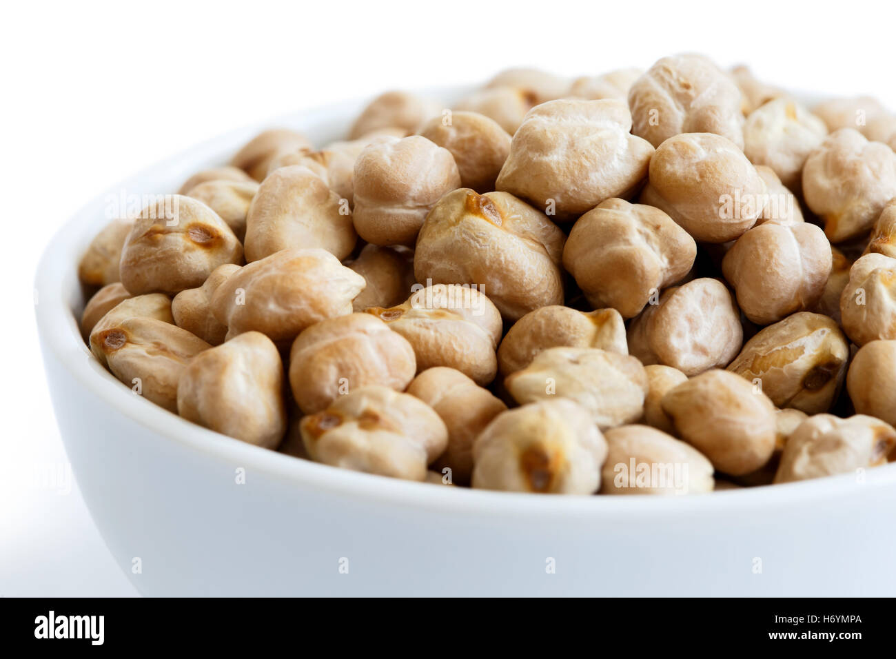 Detail of dried chickpeas in white bowl on white. Stock Photo