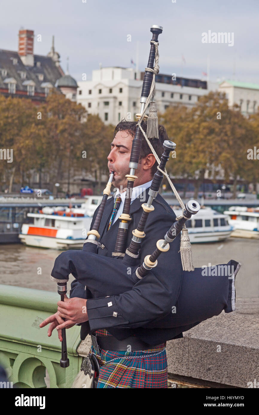London, Westminster A bagpipeplaying busker on Westminster Bridge